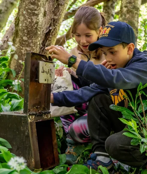 Enfants qui s'émerveillent devant un coffre et son énigme