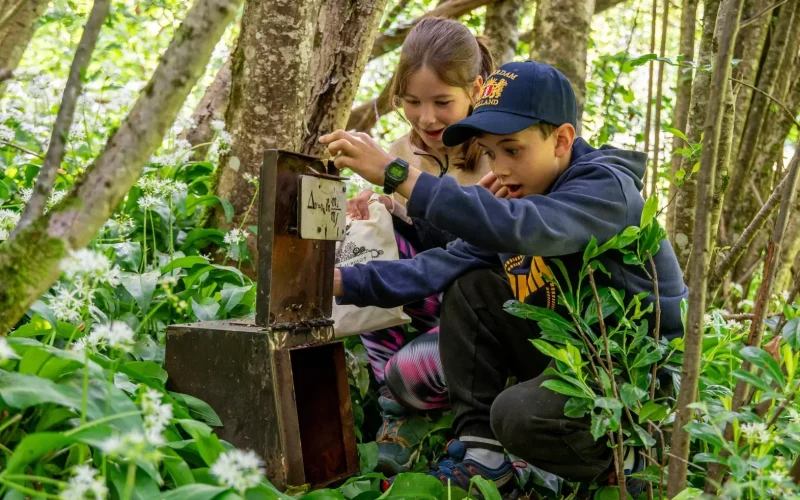 Enfants qui s'émerveillent devant un coffre et son énigme
