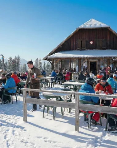 Le restaurant La Tanière à Agy sous la neige avec des personnes en terrasse
